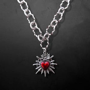 Our Thorn Heart Necklace, a stunning gothic necklace crafted with care and precision. This goth chain necklace features a striking black or red heart pendant wrapped in intricate thorn details, perfectly embodying alternative and edgy style.
Measuring approximately 16 inches in length with an Magnetic clasp. The pendant itself is compact yet bold, making a unique statement piece that enhances any gothic or punk-inspired outfit.