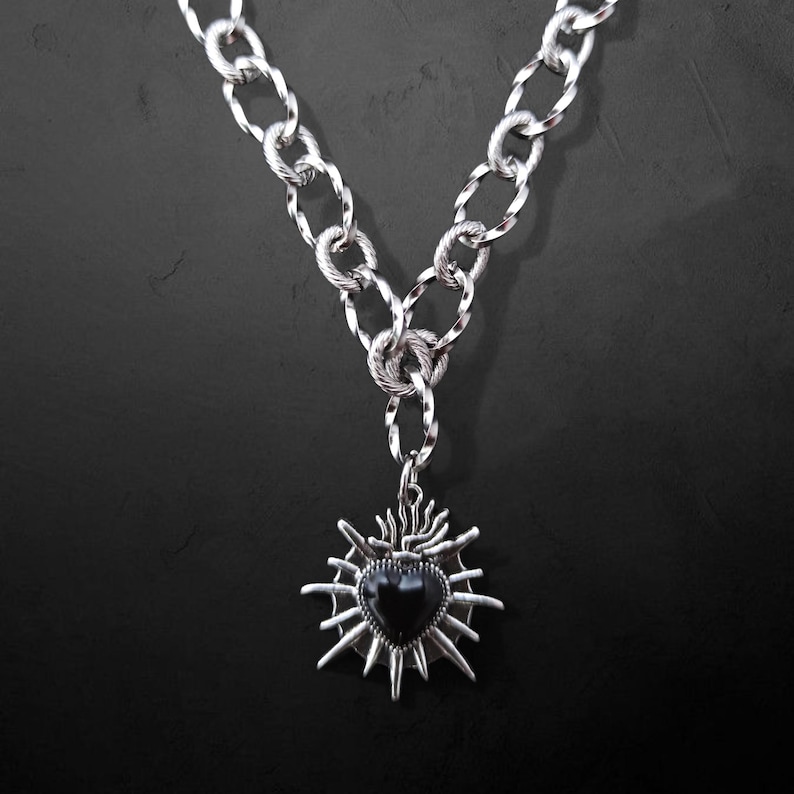 Our Thorn Heart Necklace, a stunning gothic necklace crafted with care and precision. This goth chain necklace features a striking black or red heart pendant wrapped in intricate thorn details, perfectly embodying alternative and edgy style.
Measuring approximately 16 inches in length with an Magnetic clasp. The pendant itself is compact yet bold, making a unique statement piece that enhances any gothic or punk-inspired outfit.