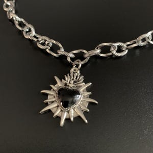 Our Thorn Heart Necklace, a stunning gothic necklace crafted with care and precision. This goth chain necklace features a striking black or red heart pendant wrapped in intricate thorn details, perfectly embodying alternative and edgy style.
Measuring approximately 16 inches in length with an Magnetic clasp. The pendant itself is compact yet bold, making a unique statement piece that enhances any gothic or punk-inspired outfit.