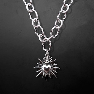 Our Thorn Heart Necklace, a stunning gothic necklace crafted with care and precision. This goth chain necklace features a striking black or red heart pendant wrapped in intricate thorn details, perfectly embodying alternative and edgy style.
Measuring approximately 16 inches in length with an Magnetic clasp. The pendant itself is compact yet bold, making a unique statement piece that enhances any gothic or punk-inspired outfit.