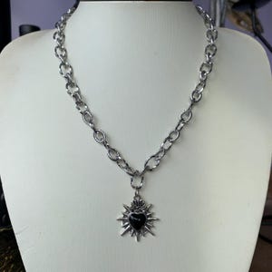Our Thorn Heart Necklace, a stunning gothic necklace crafted with care and precision. This goth chain necklace features a striking black or red heart pendant wrapped in intricate thorn details, perfectly embodying alternative and edgy style.
Measuring approximately 16 inches in length with an Magnetic clasp. The pendant itself is compact yet bold, making a unique statement piece that enhances any gothic or punk-inspired outfit.