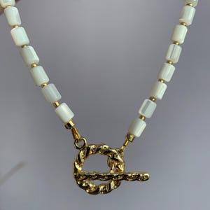 Pärlemorchoker: Elegant vitt halsband med 18k guldväxel