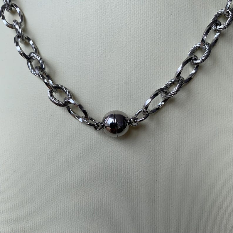 Our Thorn Heart Necklace, a stunning gothic necklace crafted with care and precision. This goth chain necklace features a striking black or red heart pendant wrapped in intricate thorn details, perfectly embodying alternative and edgy style.
Measuring approximately 16 inches in length with an Magnetic clasp. The pendant itself is compact yet bold, making a unique statement piece that enhances any gothic or punk-inspired outfit.
