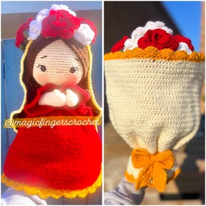 May include: Crocheted doll with a red dress and a white and red flower crown. The doll is holding its hands together in a prayer position. The doll is standing on a yellow and white crocheted base. The doll is next to a crocheted bouquet of red and white flowers with a yellow crocheted bow.
