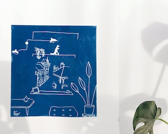 May include: A blue and white print of a room interior with furniture and plants. The print is framed and hanging on a white wall.