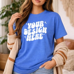 May include: A white ceramic mug with a black handle and the text "But First, Coffee" in a bold, black font. The mug is set against a blurred background, suggesting a cozy setting.