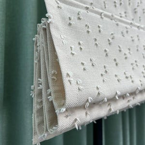Roman Blind with Linen Texture and Delicate Voluminous Cotton Puff Details