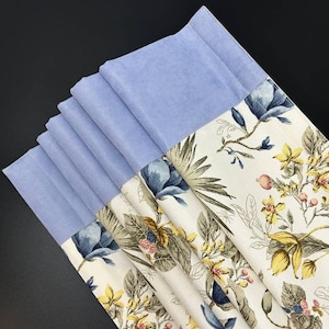 Roman shade with a delicate floral print and an elegant sky-blue velvet trim