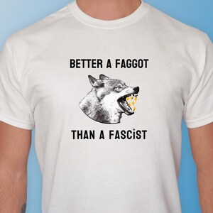 May include: White t-shirt with a wolf graphic and the text "Better a Faggot Than a Fascist".