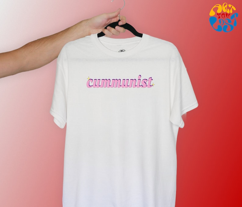 May include: White t-shirt with the word "communist" written in pink letters with a yellow star above the first letter.