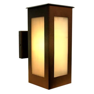 May include: A brown outdoor wall light fixture with a frosted glass panel. The light is on and illuminating the glass.