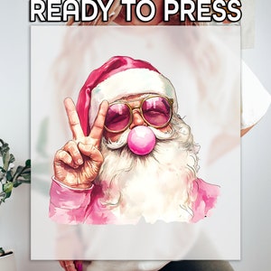 May include: A watercolor illustration of Santa Claus wearing pink sunglasses and a pink shirt, giving the peace sign with a pink bubble gum in his mouth.