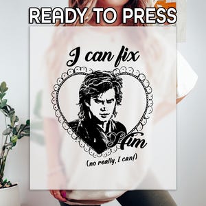 May include: White t-shirt with a black graphic. The graphic features a portrait inside a heart-shaped frame, with the text "I can fix Him" and the phrase "(no really, I can!)" below. The words "READY TO PRESS" are at the top.
