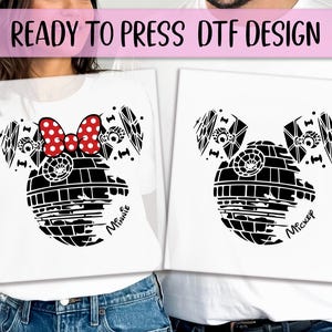 May include: White t-shirts with black graphic designs. One shirt features a red polka-dot bow and the word "Minnie". The other shirt has the word "Mickey". The design combines elements of Star Wars and Disney.