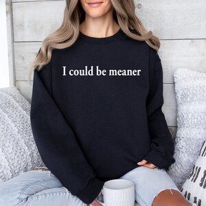 Puede incluir: Una sudadera negra con el texto "I could be meaner" impreso en blanco en la parte delantera.
