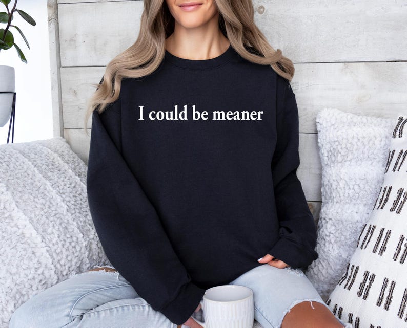 Puede incluir: Una sudadera negra con el texto "I could be meaner" impreso en blanco en la parte delantera.