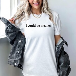 Puede incluir: Camiseta blanca con el texto "I could be meaner" impreso en negro.