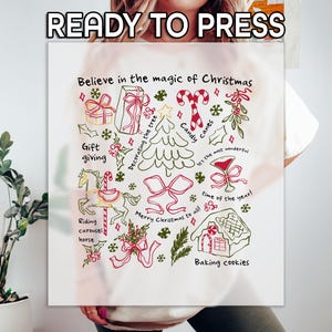 May include: A white graphic featuring Christmas-themed illustrations and text. The design includes a Christmas tree, gift boxes, candy canes, and the phrase "Believe in the magic of Christmas." The words "READY TO PRESS" are at the top.