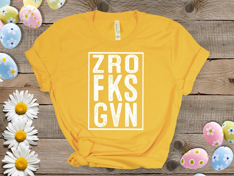 May include: Yellow t-shirt with a white box containing the text "ZRO FKS GVN".