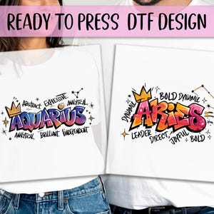 K&ouml;nnte beinhalten: Zwei wei&szlig;e T-Shirts mit farbenfrohen Grafikdesigns. Eines zeigt "Aquarius" im Graffiti-Stil mit W&ouml;rtern wie "Abstract" und "Analytical". Das andere zeigt "Aries" mit "Bold" und "Dynamic". Der Text "READY TO PRESS DTF DESIGN" steht oben.