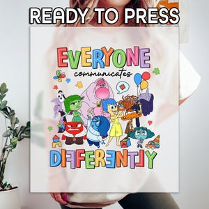 May include: White t-shirt with a colorful graphic of characters from the movie Inside Out. The text "Everyone communicates differently" is printed above the characters.