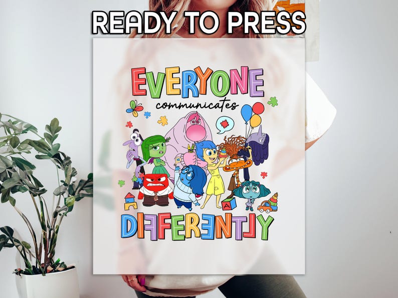 May include: White t-shirt with a colorful graphic of characters from the movie Inside Out. The text "Everyone communicates differently" is printed above the characters.