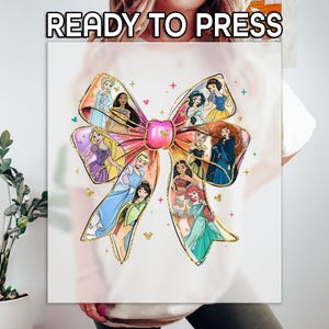 May include: A white graphic featuring a large pink bow with gold glitter accents. The bow is filled with illustrations of various princesses. The text "READY TO PRESS" is at the top of the graphic.