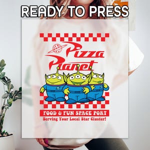 May include: White t-shirt with a red and white checkered design featuring the words "Pizza Planet" in red and three green alien characters from the movie Toy Story. The text "Food & Fun Space Port" and "Serving Your Local Star Cluster!" are also printed on the shirt.