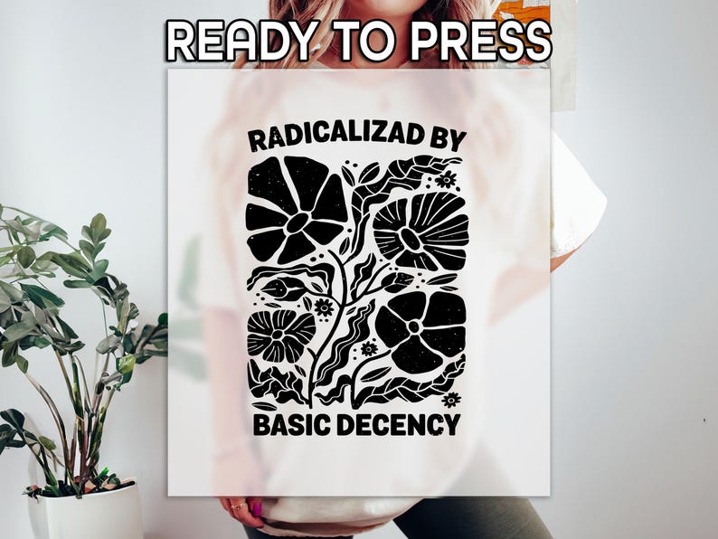 Może przedstawiać: Biała koszulka z czarnym kwiatowym wzorem i napisem "RADICALIZED BY BASIC DECENCY". Projekt przedstawia stylizowane kwiaty i liście. U g&oacute;ry widnieje napis "READY TO PRESS".