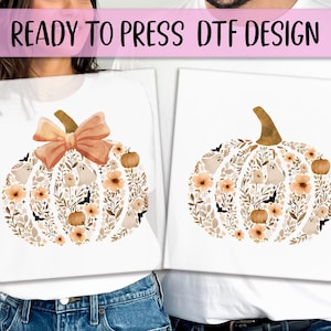 May include: White t-shirts with a pumpkin design. The pumpkin is filled with flowers, leaves, ghosts, and bats in shades of orange, brown, and beige. The text "READY TO PRESS DTF DESIGN" is at the top.