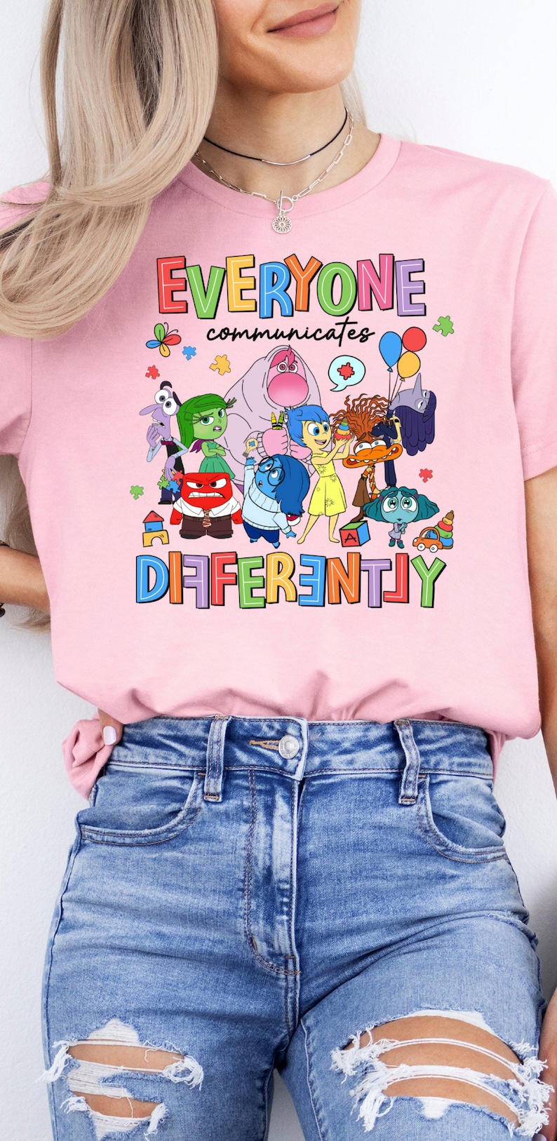 May include: Pink t-shirt with a graphic of characters from the movie Inside Out. The text on the shirt reads "Everyone communicates differently".