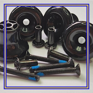 Op de afbeelding: Een assortiment zwarte rolschaatswielen, bevestigingsmateriaal en schroeven. De wielen zijn glanzend en rond met een centraal gat. De schroeven hebben blauwe accenten. De hardware omvat cilindrische palen en schroeven met platte kop.