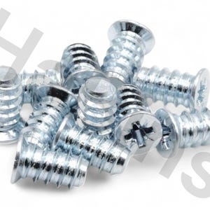 May include: A close-up shot of a pile of silver-colored screws. Each screw has a flat head with a cross-shaped indentation and a threaded body. The screws are likely for furniture assembly or general hardware use.