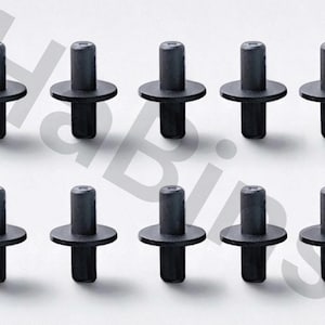 Puede incluir: Diez remaches de plástico negro están dispuestos en dos filas de cinco. Cada remache tiene una cabeza cilíndrica, una brida circular y un poste cilíndrico. Los remaches están diseñados para una fijación segura.