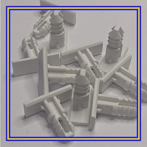 Op de afbeelding: Een verzameling witte kunststof duwrivetten, bevestigingsmiddelen of clips, ontworpen voor een veilige bevestiging. De bevestigingsmiddelen hebben een rechthoekige basis en een cilindrisch, geribbeld lichaam met een puntig uiteinde. Ze worden waarschijnlijk gebruikt in de auto- of bouwsector.