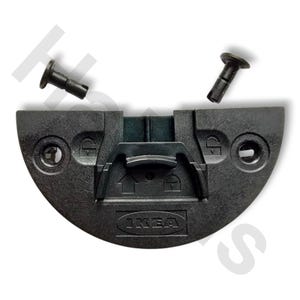 May include: A black IKEA furniture connector with two black dowel pins. The connector is semi-circular with a central locking mechanism and two screw holes. The IKEA logo is visible on the connector.