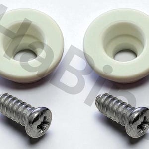 Puede incluir: Dos topes de armario circulares de color blanquecino con un agujero central, combinados con dos tornillos plateados. Los topes tienen un diseño liso y redondeado. Los tornillos tienen cabeza Phillips.