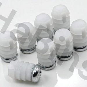 May include: A collection of eight white and silver automotive parts. The parts have a cylindrical shape with a ribbed design on the white portion and a silver base. One part is lying on its side.