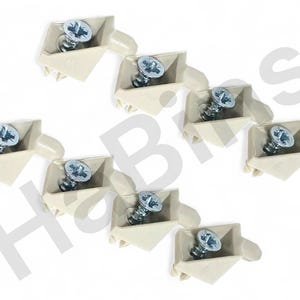 Może przedstawiać: Zdjęcie z góry ośmiu narożników meblowych z kremowego tworzywa sztucznego, każdy ze srebrną śrubą. Narożniki ułożone są w luźny wzór na białym tle. Okucia do naprawy mebli.