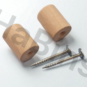 May include: Two cylindrical wooden knobs in a light brown colour, each with a central hole. Two silver screws with flat heads are also present. The items are arranged on a white surface.