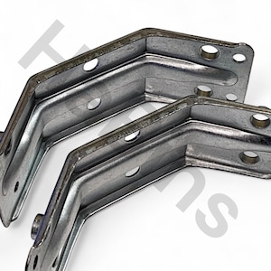 Op de afbeelding: Twee zilverkleurige metalen hoekbeugels met meerdere gaten voor schroeven. De beugels zijn in een hoek van 90 graden gebogen. Deze worden waarschijnlijk gebruikt voor meubels of bouwprojecten. De beugels zijn van metaal.