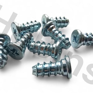 May include: A collection of silver-colored screws with Phillips head slots. The screws have a coarse thread and a wide, flat head. The hardware is designed for wood or metal applications. The screws are arranged on a white background.