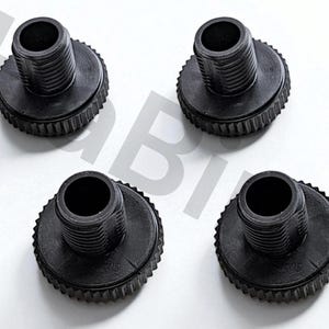 Può includere: Quattro raccordi in plastica nera con una parte superiore filettata e una base circolare scanalata. I raccordi sono disposti su una superficie bianca. La parte superiore di ogni raccordo ha un'apertura cava.
