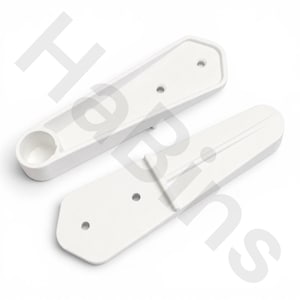 May include: Two white plastic components with an elongated, tapered shape. One piece features a circular recessed cup at one end and two small circular holes. The other piece has a raised central ridge and two small circular holes for mounting.