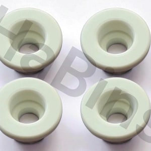 May include: Four light green, circular objects with a central hole and a slightly raised outer rim. The objects are evenly spaced and appear to be made of a smooth, solid material. The design is simple and functional.