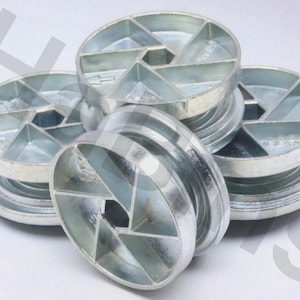 May include: A collection of silver-colored, circular metal objects. Each object has a central hexagonal hole surrounded by six triangular sections, creating a geometric design. The objects are stacked and scattered, showcasing their unique shape.