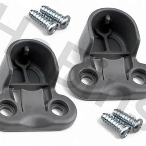 May include: Two gray plastic brackets with two screws each, arranged on a white background. The brackets have a curved top and two holes at the base. The screws are silver.