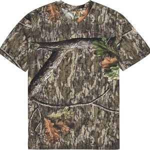 May include: A short-sleeved camouflage t-shirt featuring a woodland pattern in shades of brown, green, and tan. The design incorporates tree branches and leaves, creating a naturalistic camouflage effect. The shirt has a crew neck and a relaxed fit.