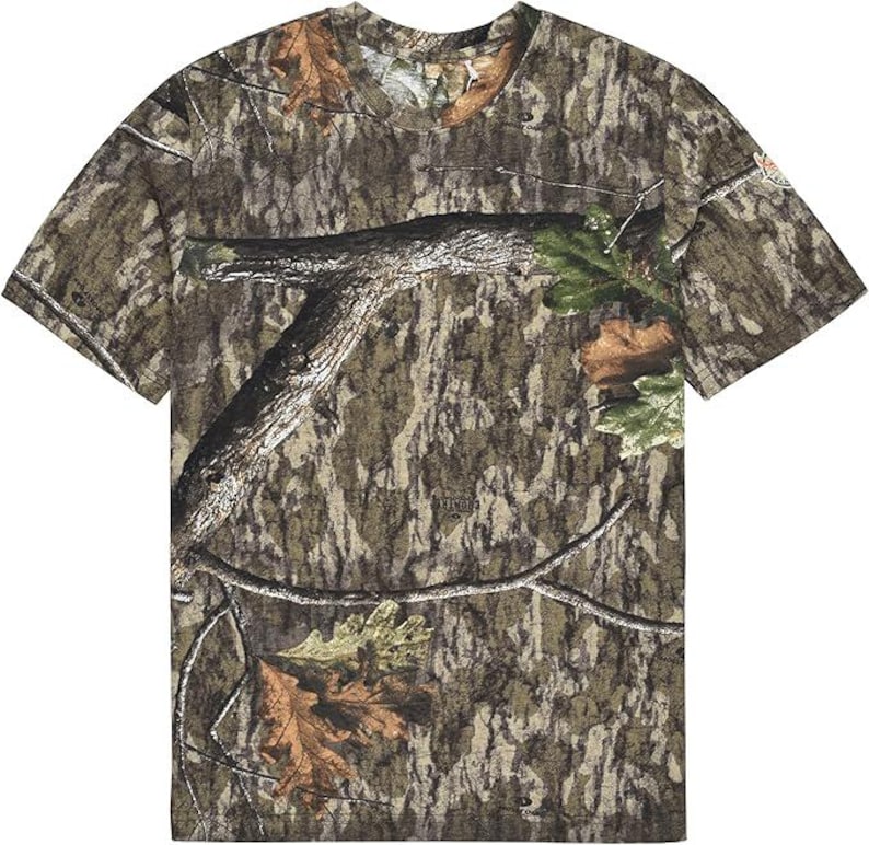 May include: A short-sleeved camouflage t-shirt featuring a woodland pattern in shades of brown, green, and tan. The design incorporates tree branches and leaves, creating a naturalistic camouflage effect. The shirt has a crew neck and a relaxed fit.