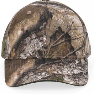 May include: A baseball cap featuring a realistic forest camouflage pattern in shades of brown, tan, gray, and dark green. The cap has a structured six-panel crown, a curved brim, and a button at the top center, displaying a detailed bark and leaf print.